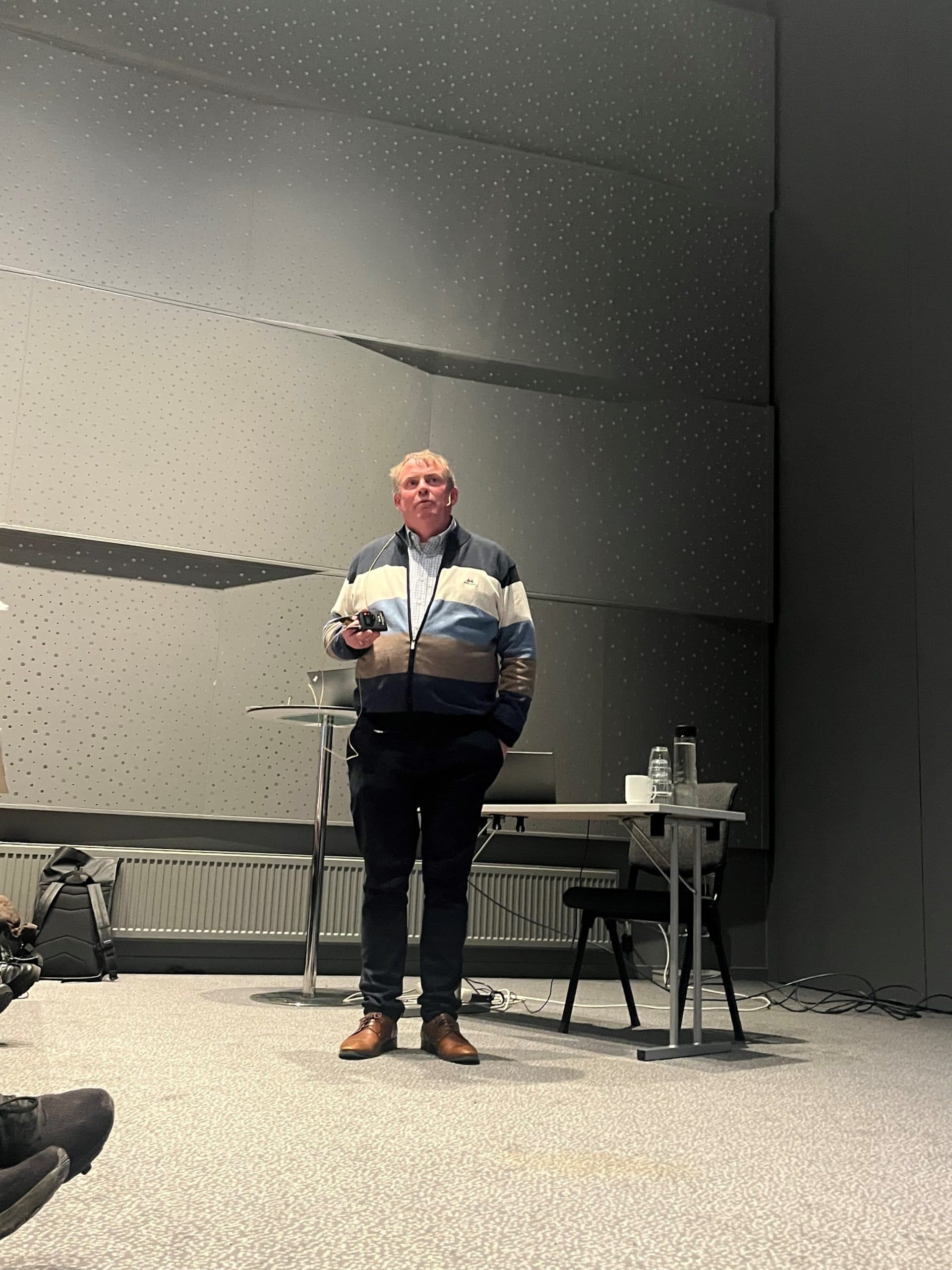 Kristian Svendsen står på scenen og snakker.